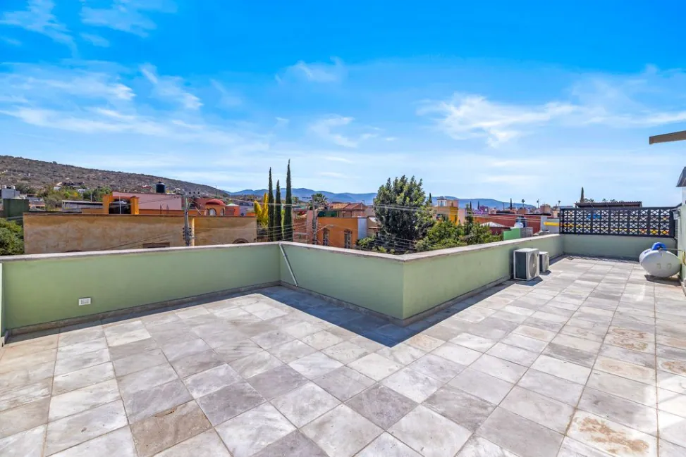 Casa Angel, roof terrace with stone paving and views toward the hills, San Miguel de Allende