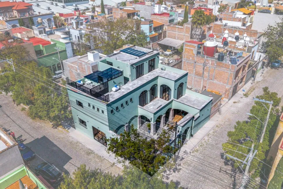 Casa Angel, aerial view of the green house with its rooftop terrace and neighboring streets, San Miguel de Allende