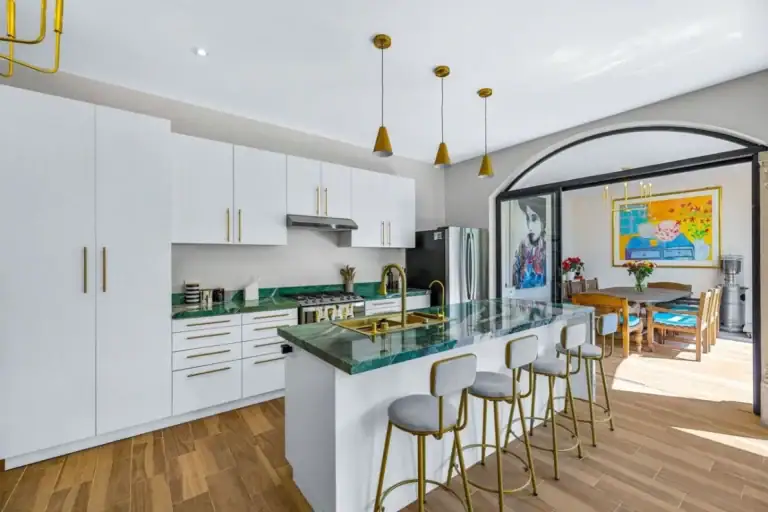 Casas Angel & Angelito, kitchen with white cabinets, a green marble island and counter stools, San Miguel de Allende