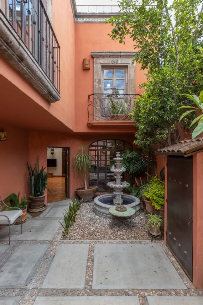 Casa Brillante, small courtyard with a stone fountain and terracotta walls, San Miguel de Allende