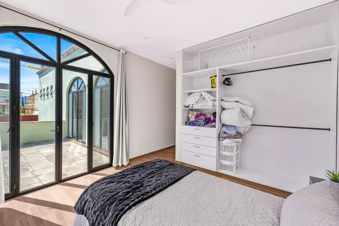 Casas Angel & Angelito, bedroom with arched glass doors to the terrace and a built-in closet, San Miguel de Allende