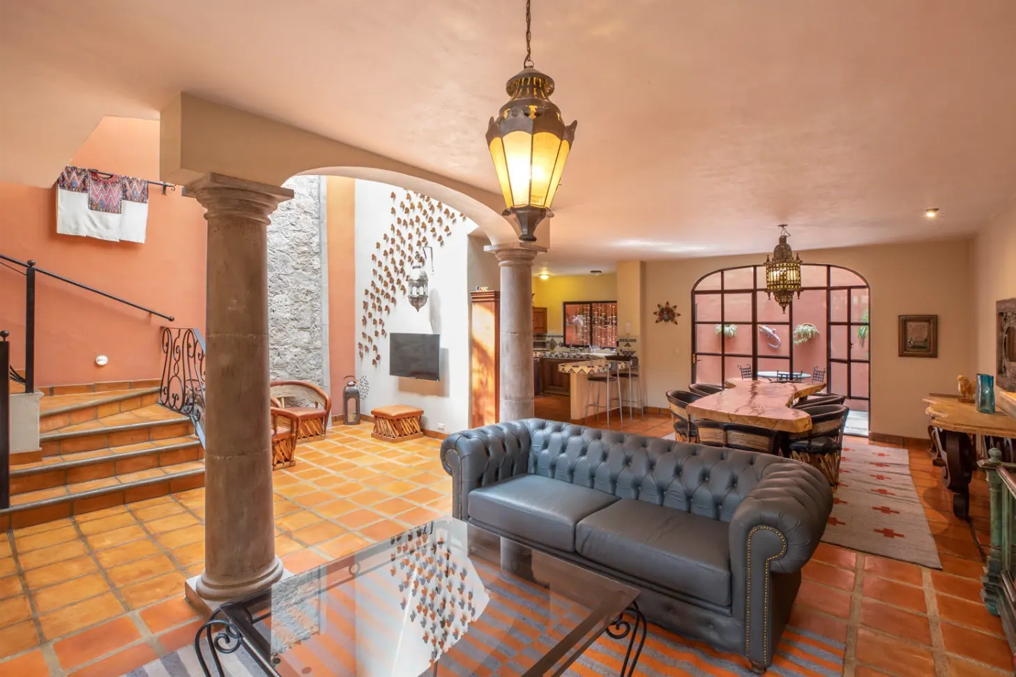 Casa Brillante, living room with a leather sofa, stone columns and terracotta floors, San Miguel de Allende