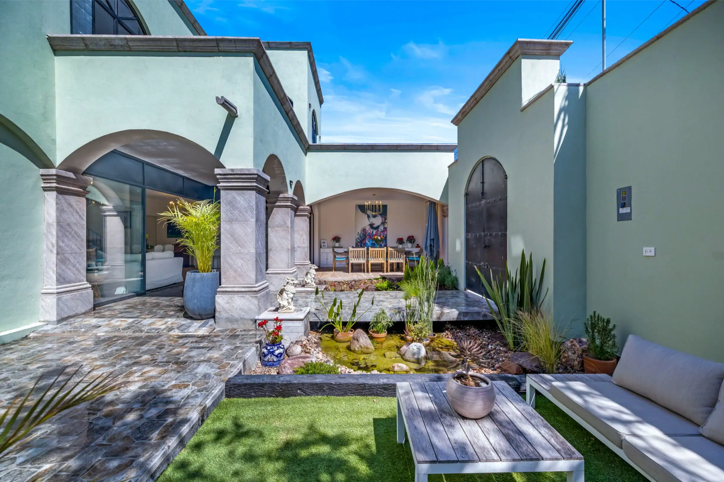 Casa Angel, courtyard with a lawn, lounge seating and an arched portico, San Miguel de Allende