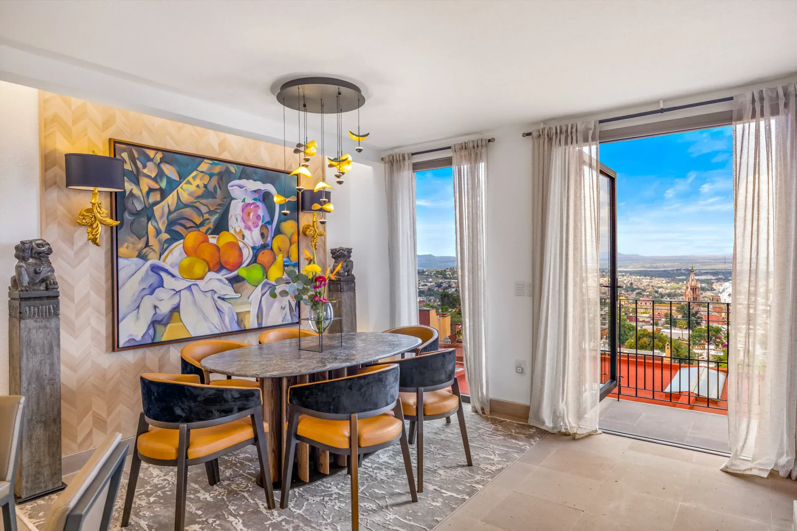 Casa Romana, dining room with an oval table and a balcony view of the city, San Miguel de Allende