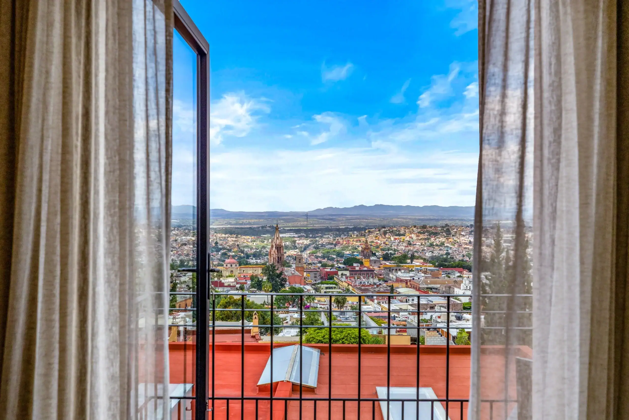 Casa Romana, view of the city through the balcony doors, San Miguel de Allende