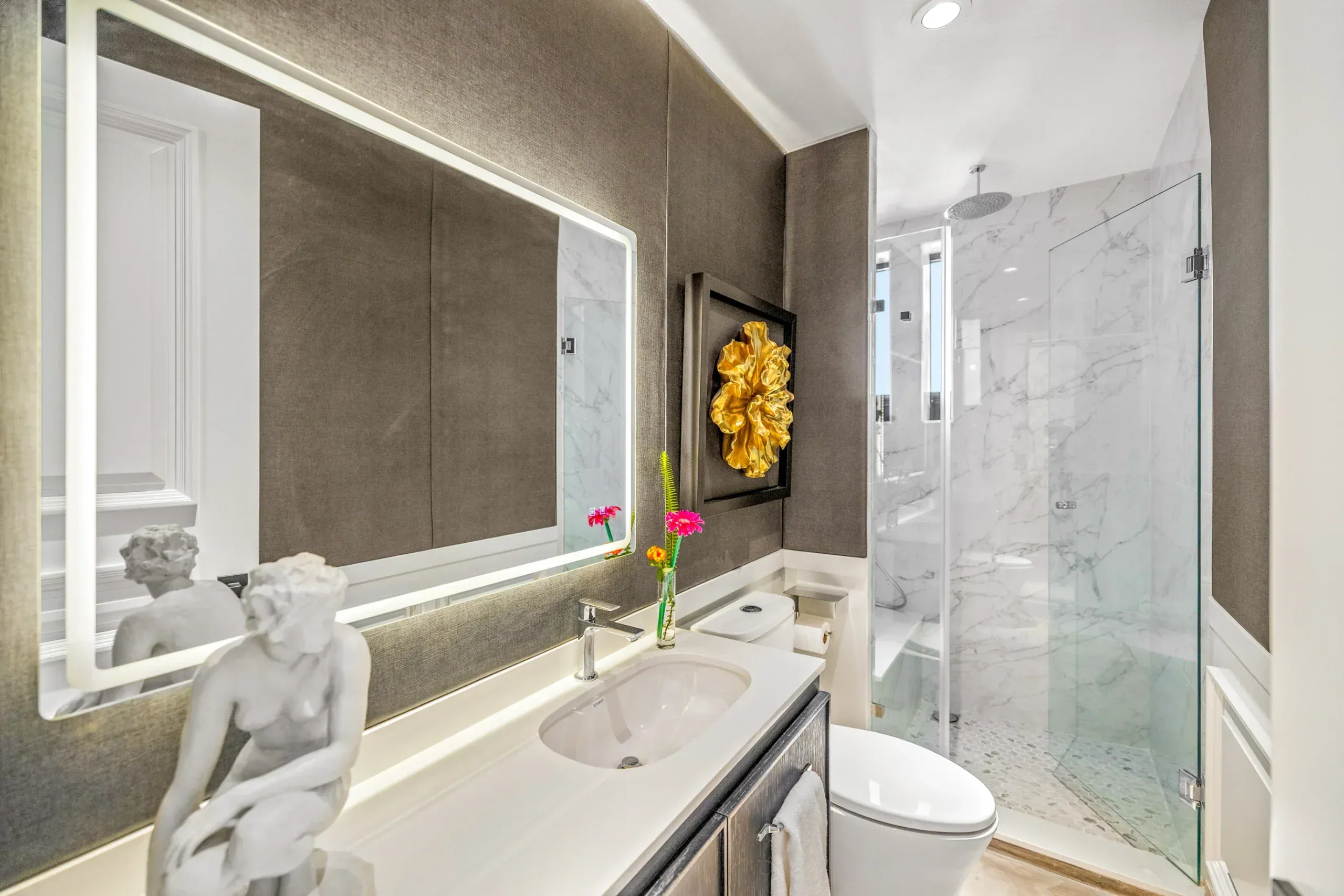 Casa Romana, bathroom with a lit mirror, a white marble shower and a sculpture, San Miguel de Allende