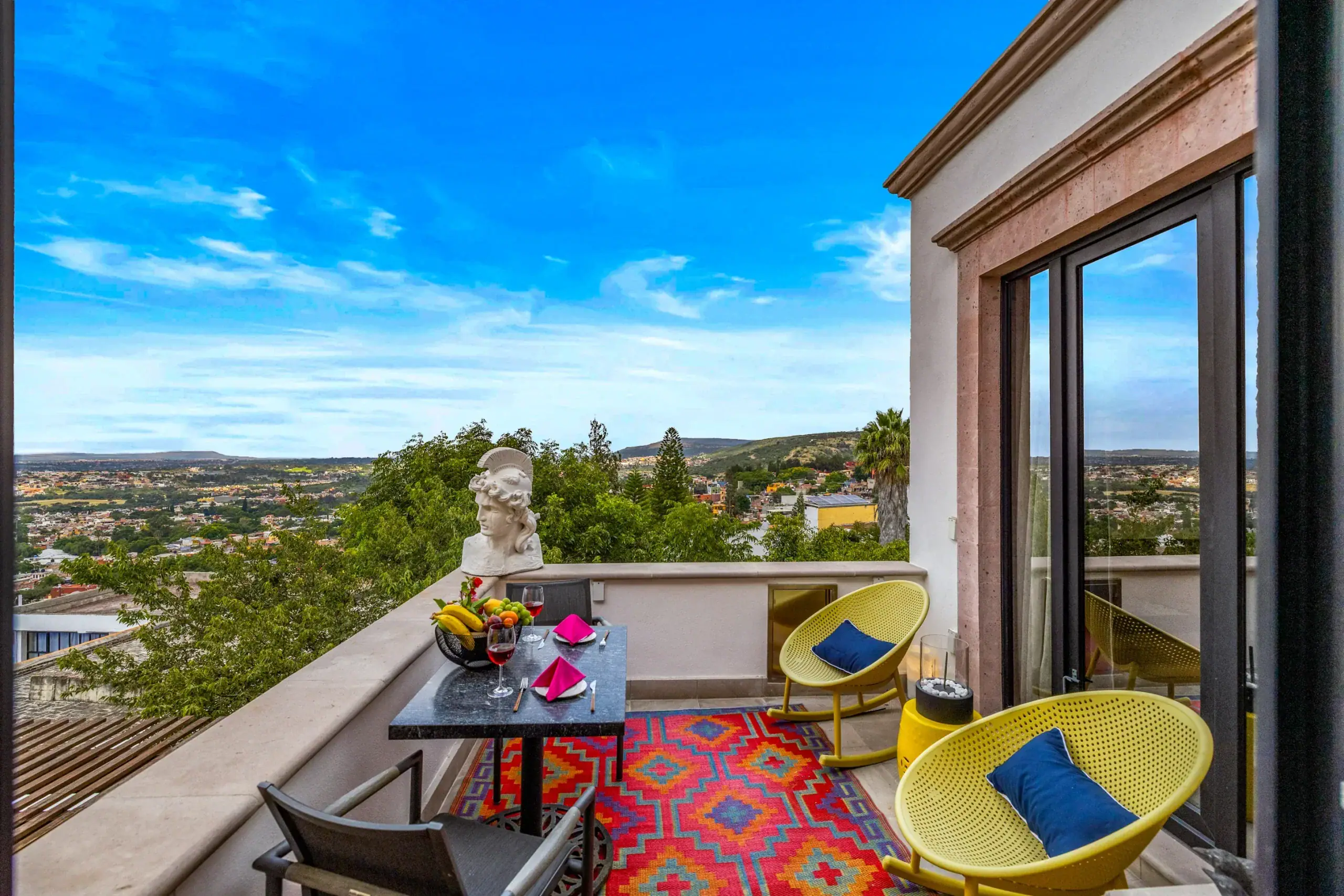 Casa Romana, terrace with a bistro table, yellow chairs and wide views, San Miguel de Allende