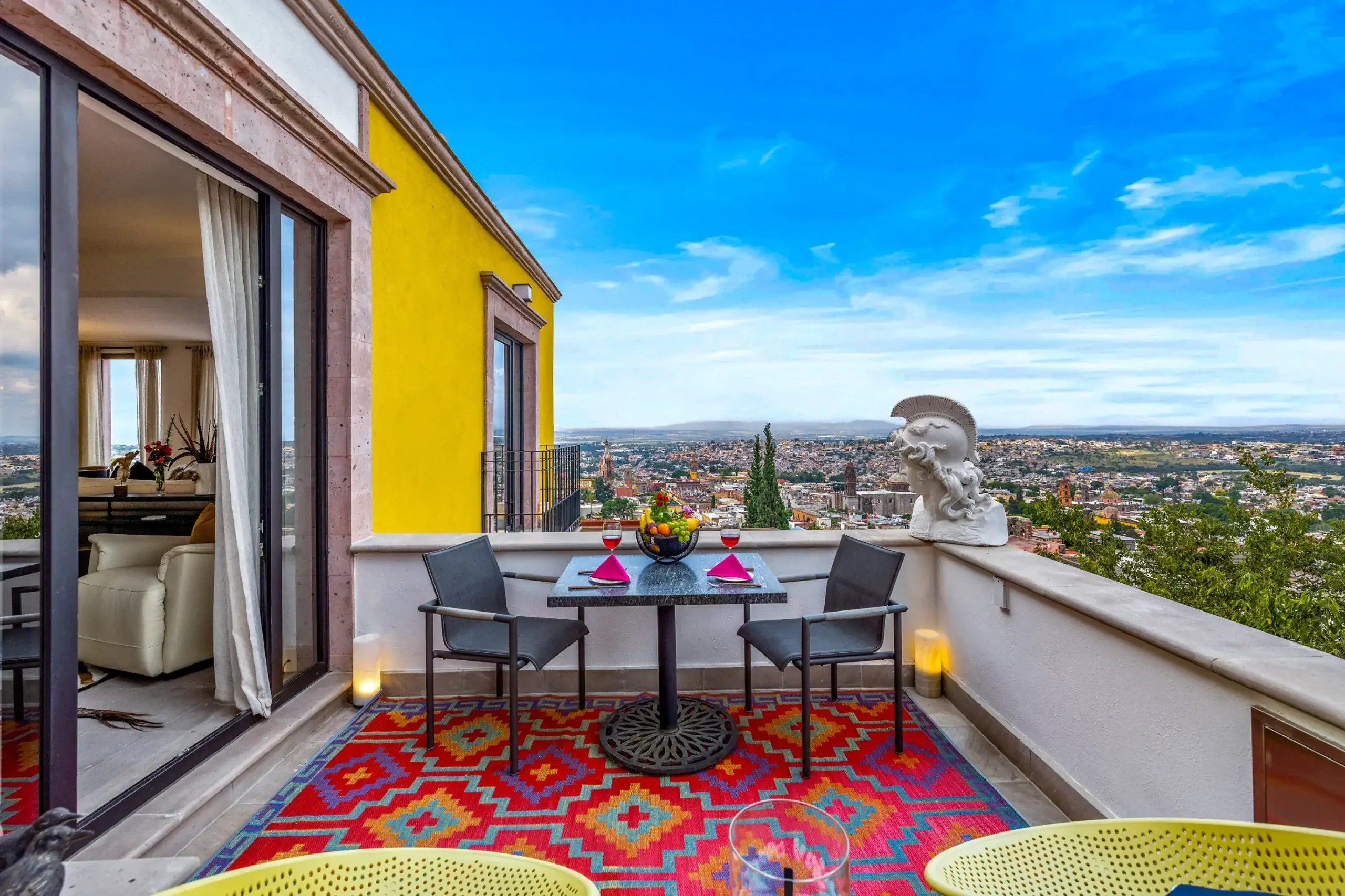 Casa Romana, terrace with a table for two, a colorful rug and city views, San Miguel de Allende