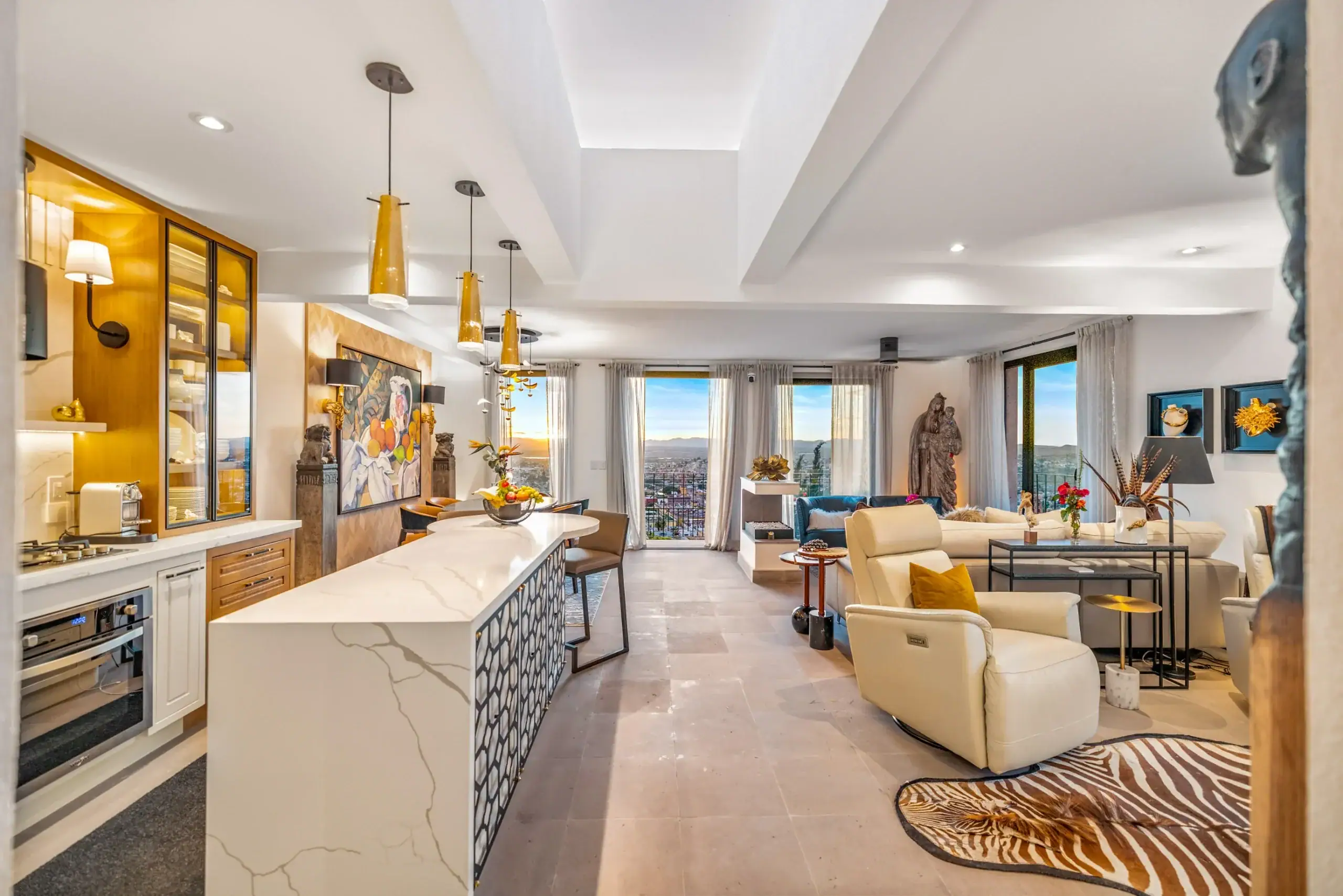 Casa Romana, great room and kitchen at dusk with the city lights beyond, San Miguel de Allende