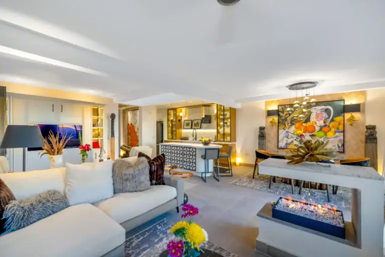 Casa Romana, living room with a white sofa, a linear fireplace and a colorful still-life painting, San Miguel de Allende