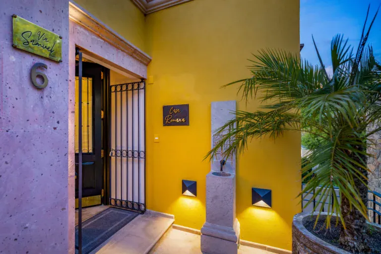 Casa Romana, entrance door with yellow walls at dusk, San Miguel de Allende