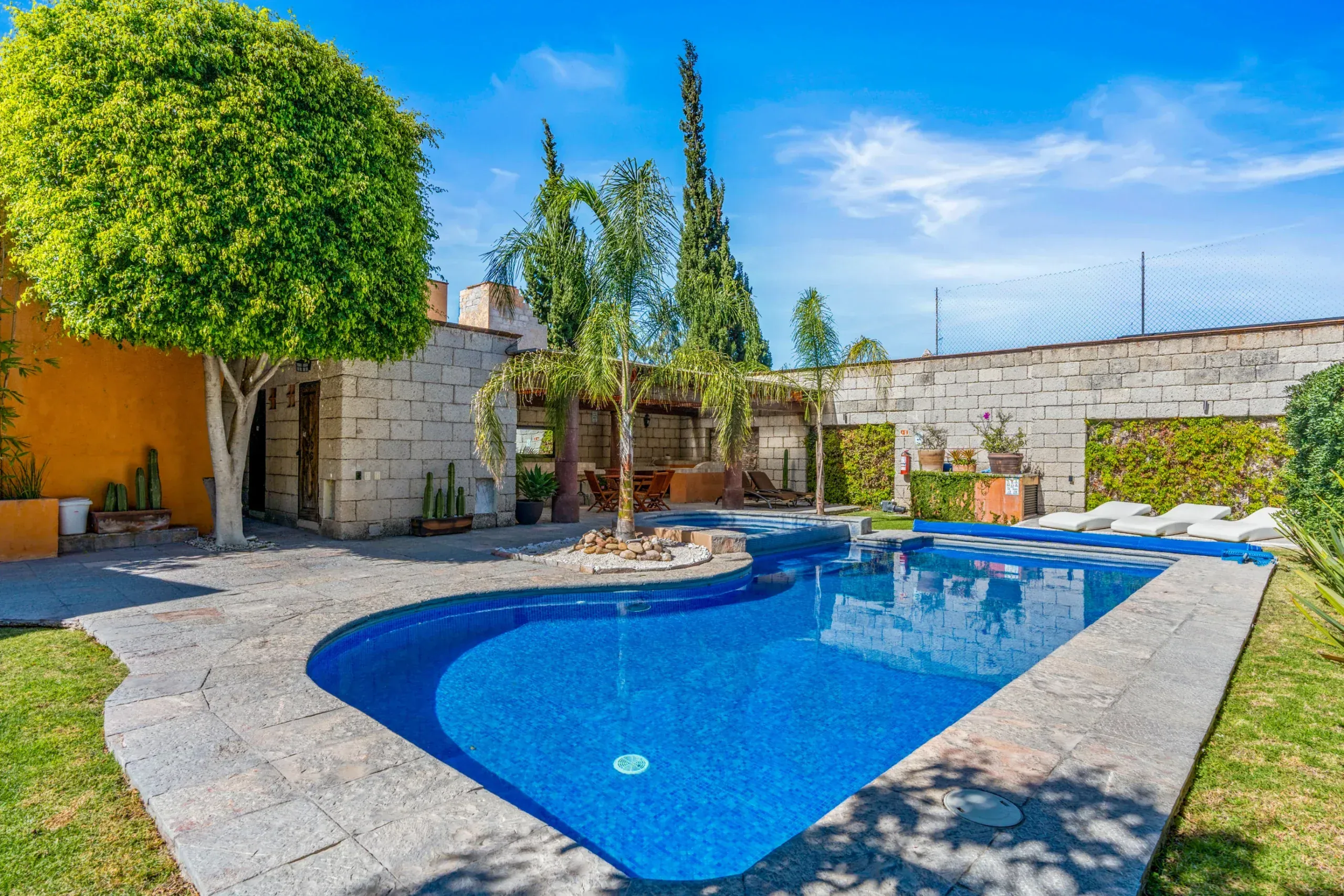 Casa Romana, swimming pool surrounded by gardens and palms, San Miguel de Allende