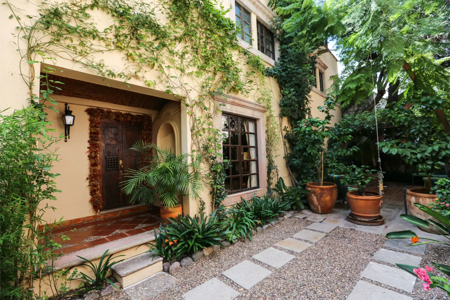 Casa Privada Baeza, entry courtyard with a stepping-stone path and climbing vines, San Miguel de Allende