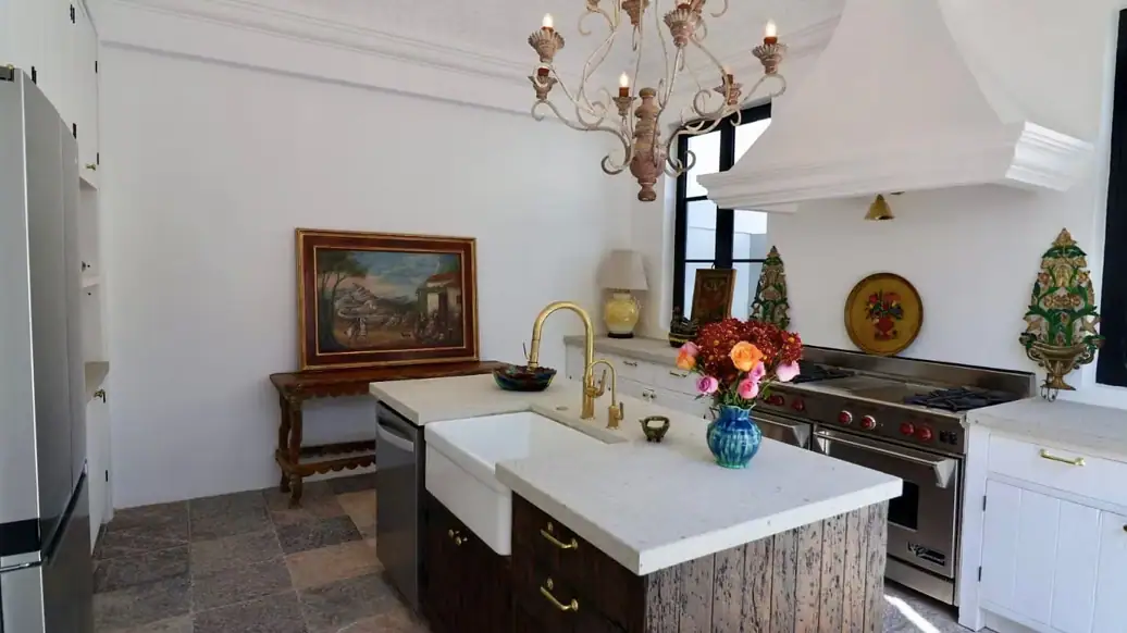 Bright white kitchen with a central island, gold faucet, and a vase of colorful flowers on the counter, San Miguel de Allende
