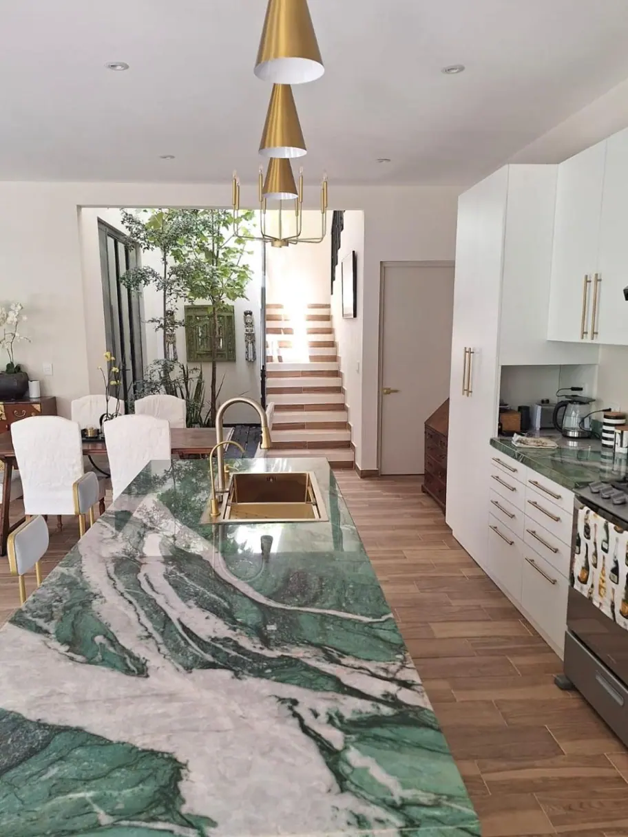 Casa Angel, kitchen with a green marble island and stairs in the background, San Miguel de Allende