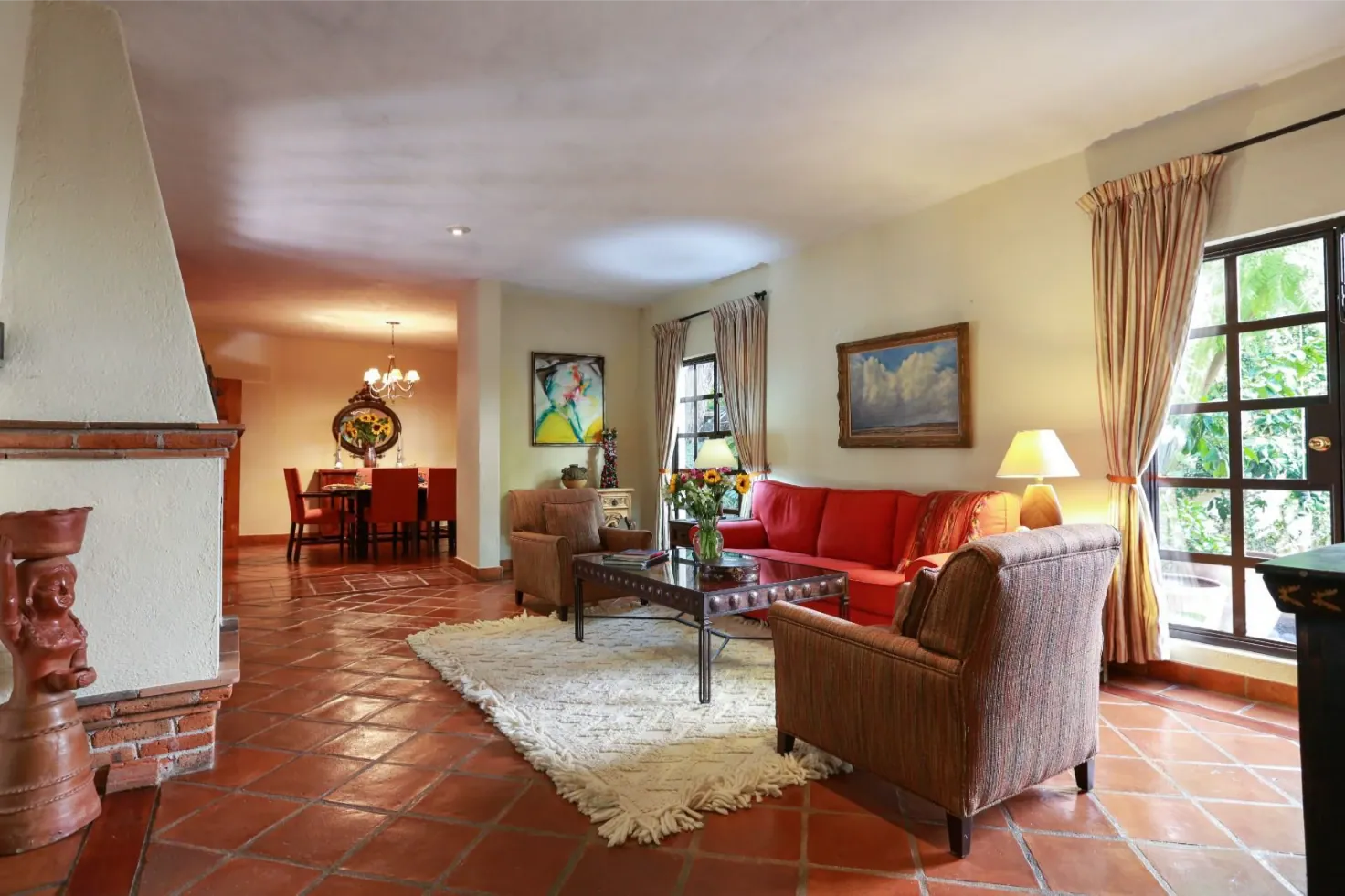 Casa Privada Baeza, living and dining room with a fireplace and terracotta floors, San Miguel de Allende