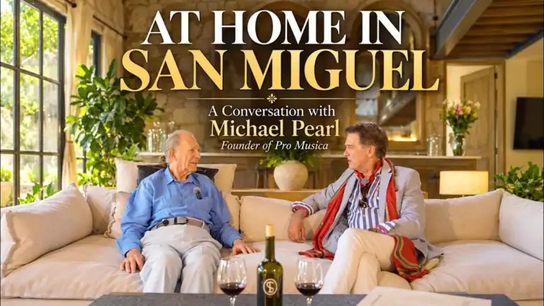 Greg Gunter and Michael Pearl seated on a white sofa with glasses of red wine, titled 'At Home in San Miguel: A conversation with Michael Pearl, Founder of Pro Musica'