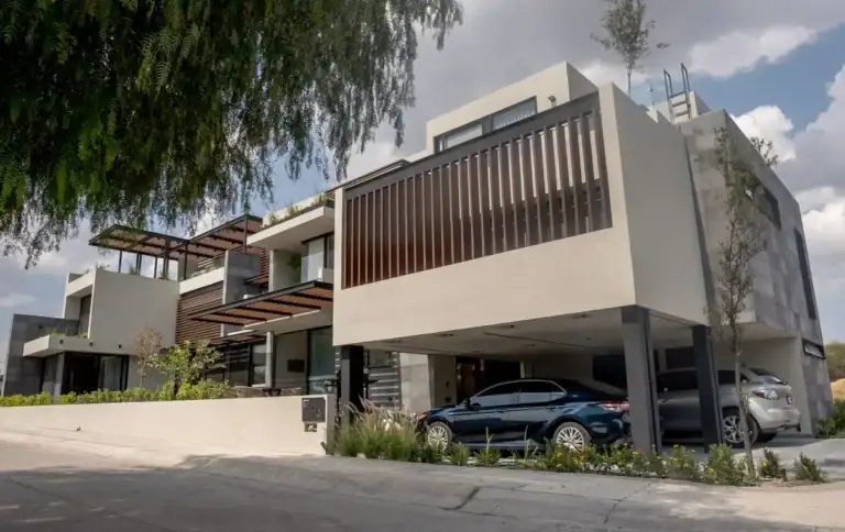 Bright House, modern two-story house with a wood-slat balcony and a covered carport on a corner lot at the golf club, San Miguel de Allende