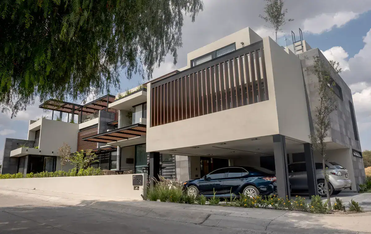 Bright House, modern two-story house with a wood-slat balcony and a covered carport on a corner lot at the golf club, San Miguel de Allende