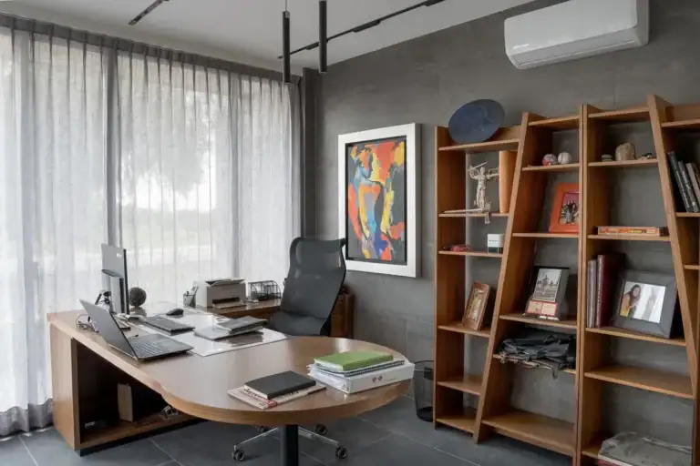 Bright House, home office with a curved wood desk, a leather chair, tilted shelves and a colorful painting, San Miguel de Allende
