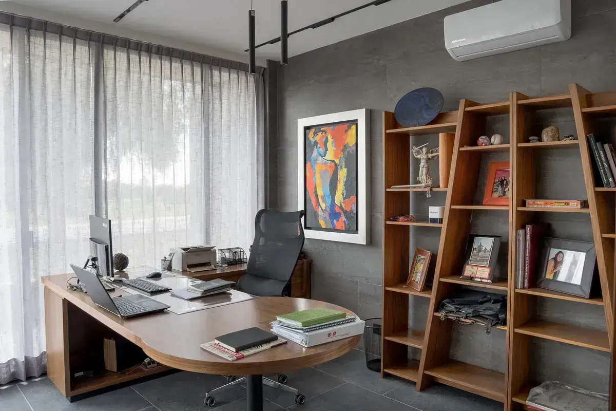 Bright House, home office with a curved wood desk, a leather chair, tilted shelves and a colorful painting, San Miguel de Allende
