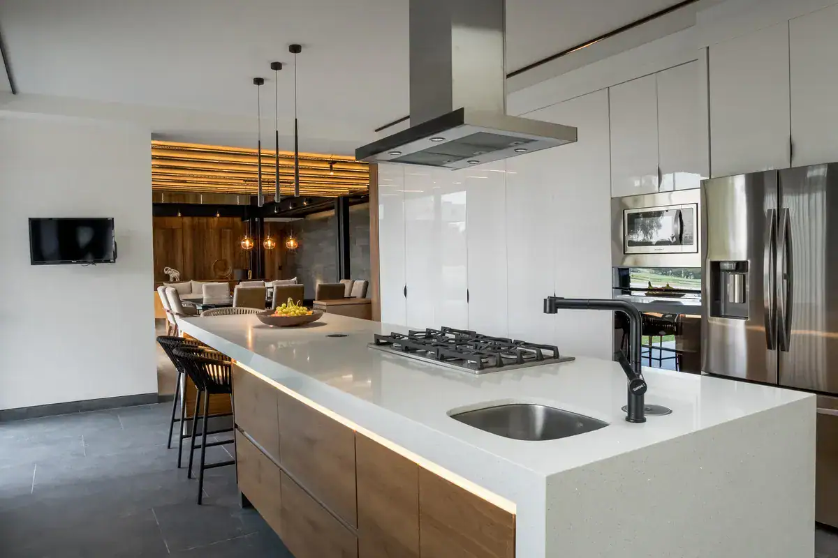 Bright House, kitchen island with a gas cooktop, a stainless refrigerator and pendant lights, San Miguel de Allende