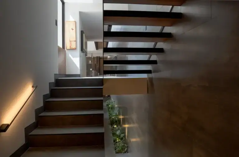Bright House, floating wood and steel staircase lit from below with a planter at the base, San Miguel de Allende