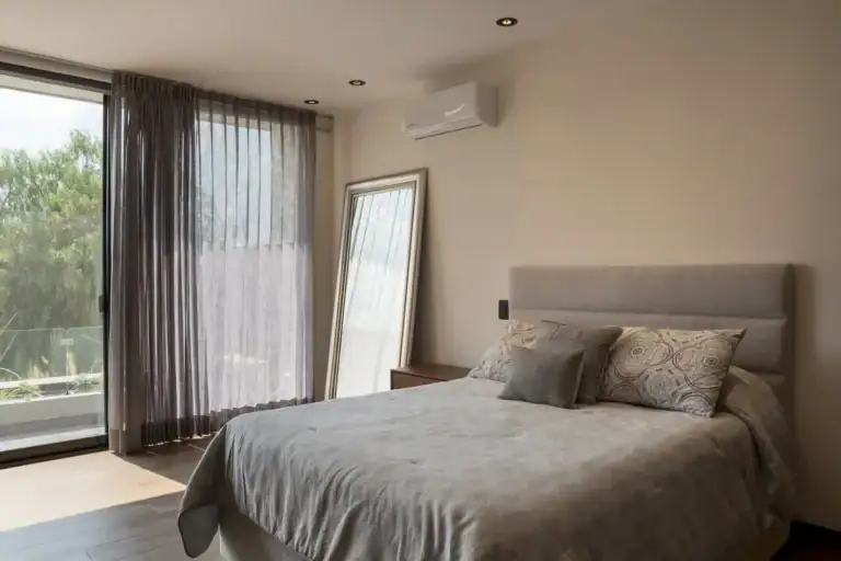 Bright House, bedroom with a gray headboard, a mirror and a large window with sheer curtains, San Miguel de Allende