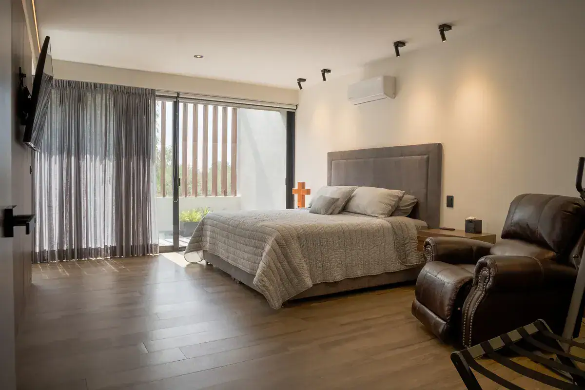 Bright House, primary bedroom with a gray headboard, a leather recliner and a television, San Miguel de Allende