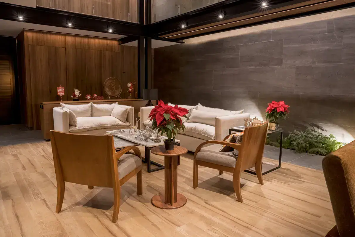 Bright House, sitting area with two sofas and a red poinsettia under a double-height ceiling at night, San Miguel de Allende