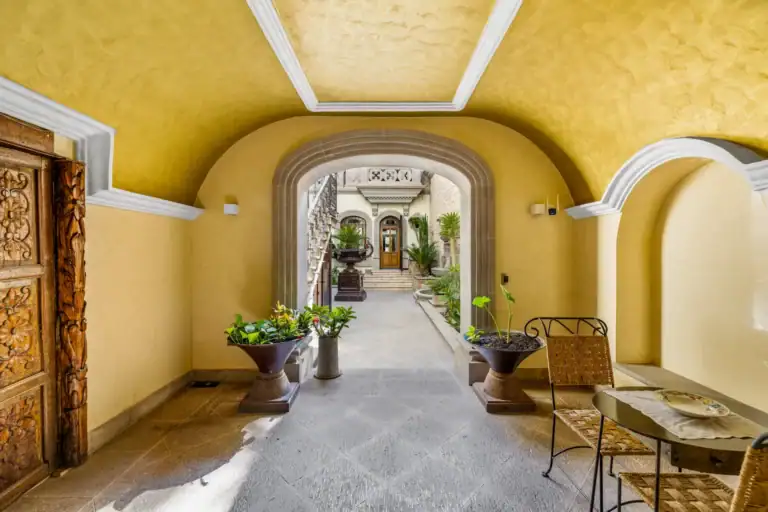 Casa 28 de Abril Norte, vaulted entrance gallery with a carved wooden door and a view to the courtyard, San Miguel de Allende