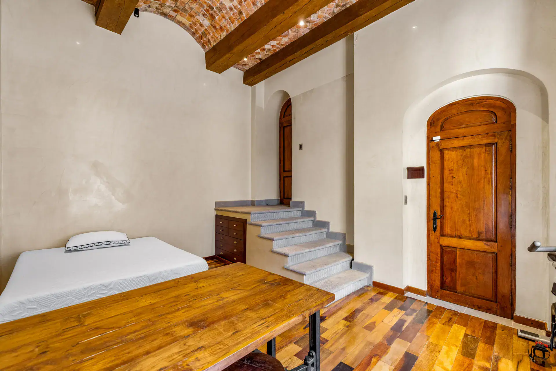 Casa 28 de Abril Norte, bedroom with a mattress, stone steps, wood desk and brick vaulted ceiling, San Miguel de Allende