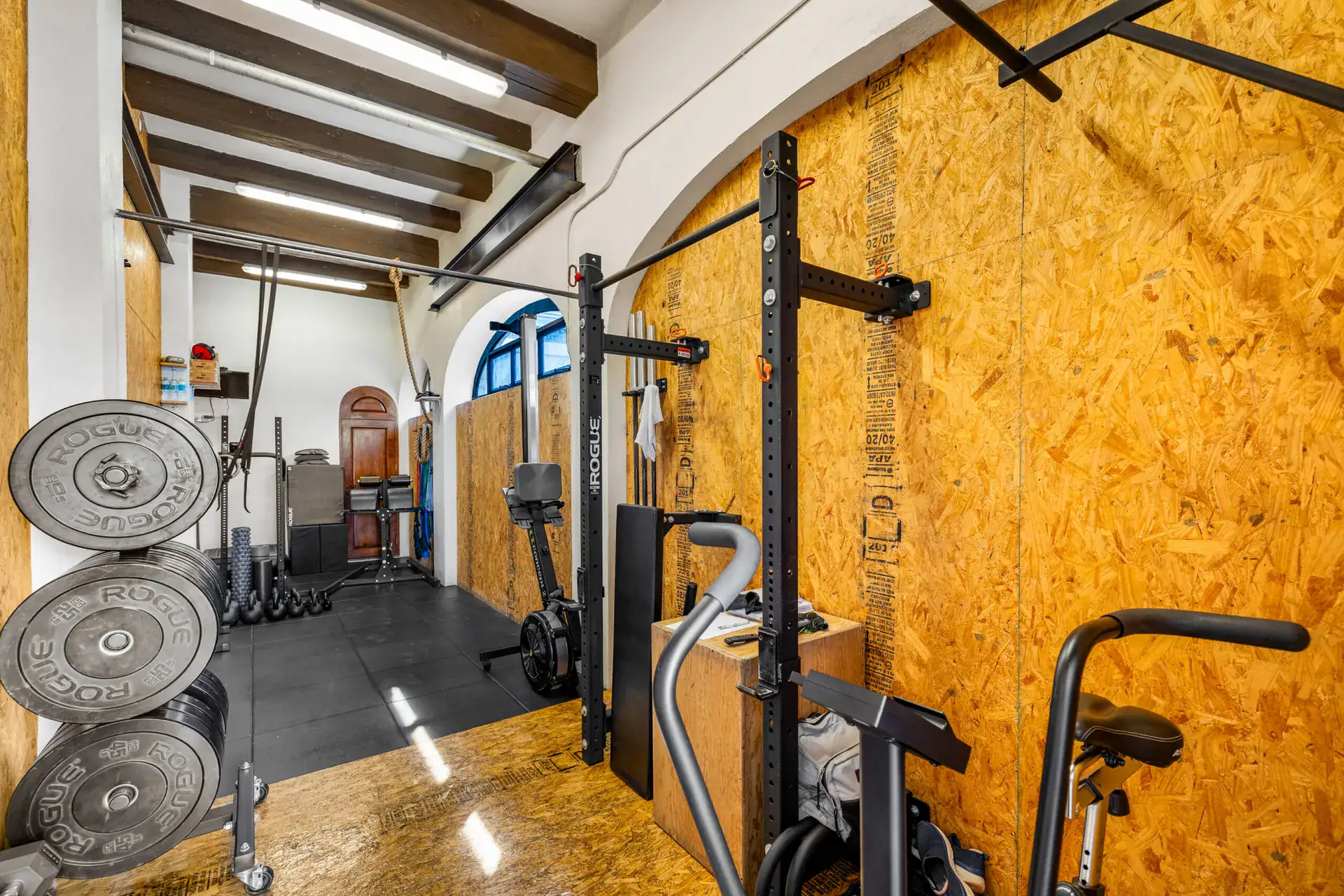 Casa 28 de Abril Norte, home gym with weight plates, a squat rack and an air bike, San Miguel de Allende