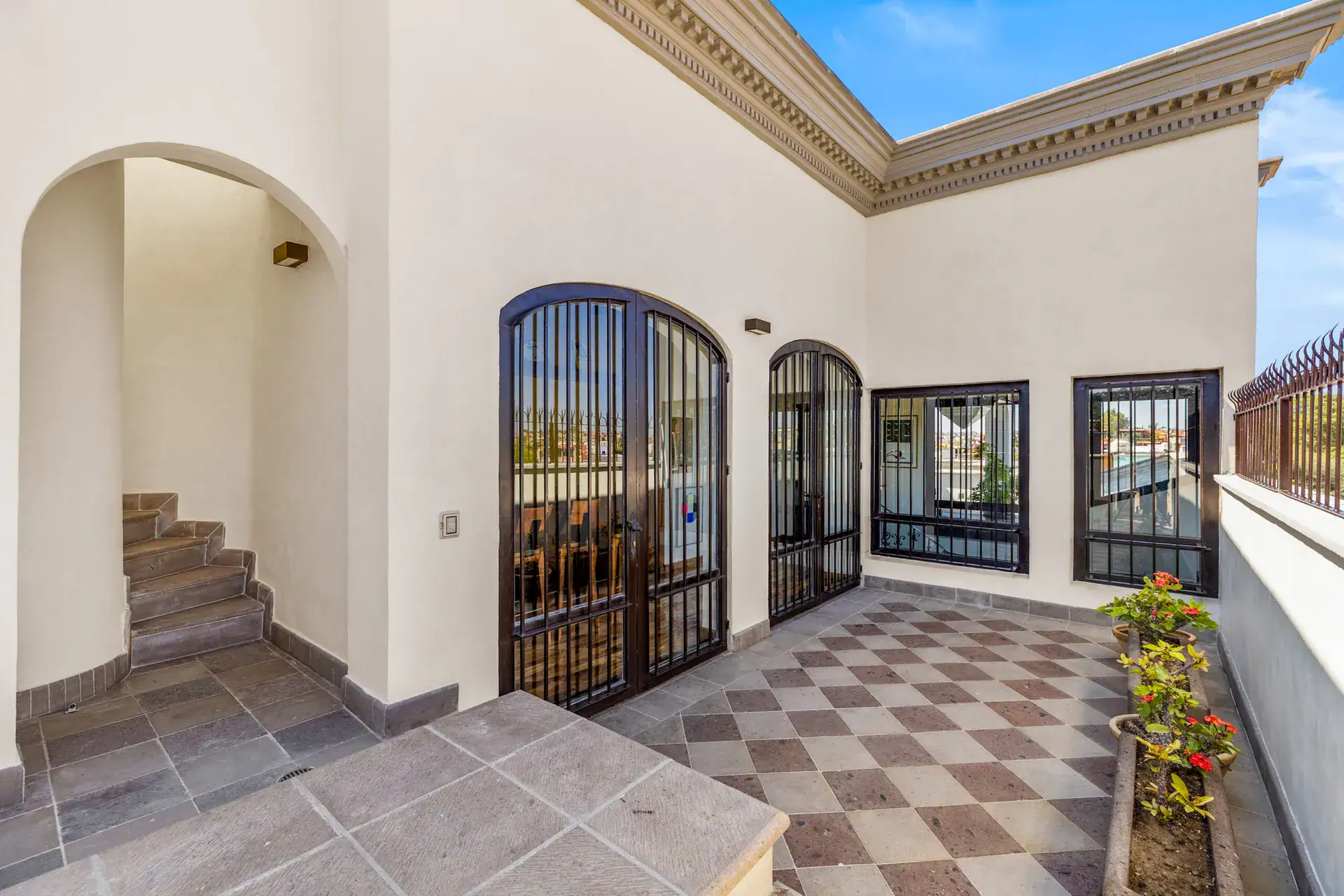 Casa 28 de Abril Norte, upper terrace with a checkerboard floor and arched barred doors, San Miguel de Allende