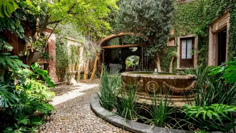 Casa Adelita, courtyard garden with a stone fountain and a pebble path, San Miguel de Allende
