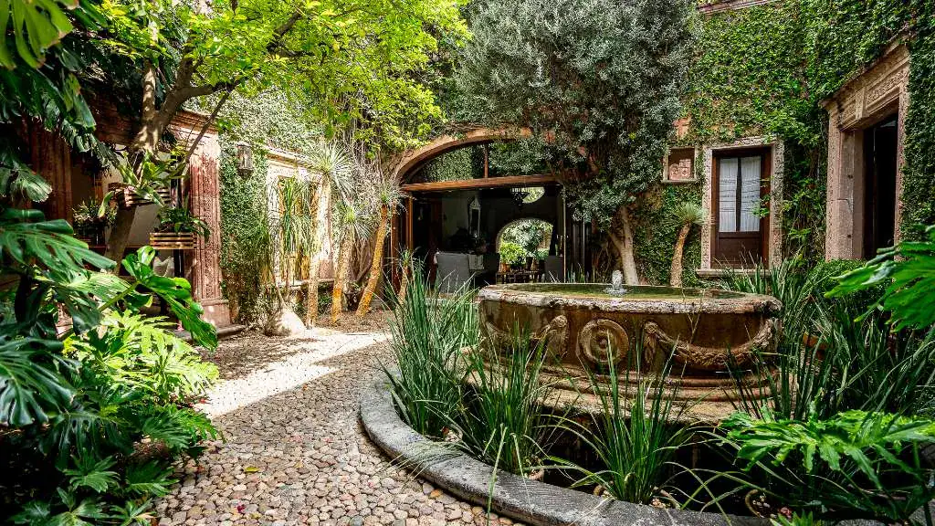 Casa Adelita, courtyard garden with a stone fountain and a pebble path, San Miguel de Allende