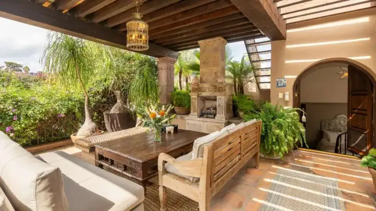 Casa Adelita, covered terrace with a fireplace and wood outdoor furniture, San Miguel de Allende