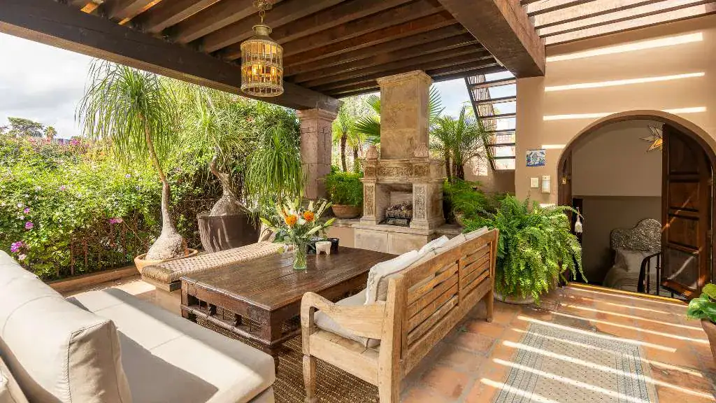 Casa Adelita, covered terrace with a fireplace and wood outdoor furniture, San Miguel de Allende