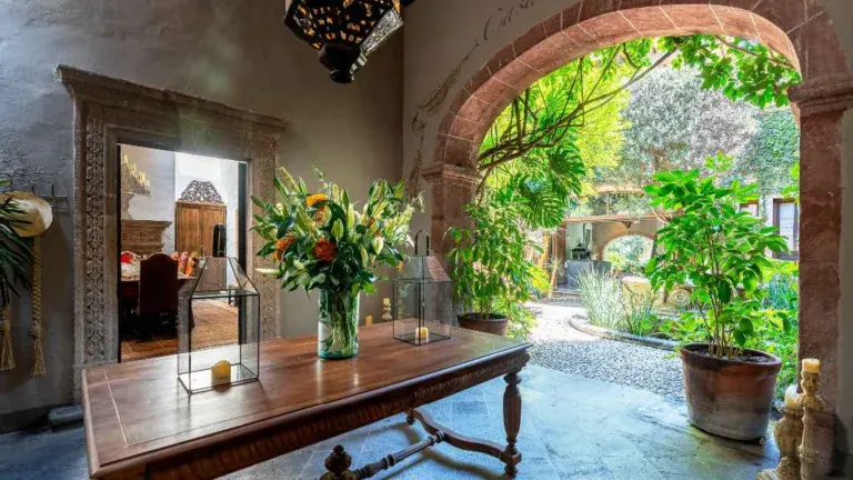 Casa Adelita, stone arch opening to the garden beside a wood console table, San Miguel de Allende