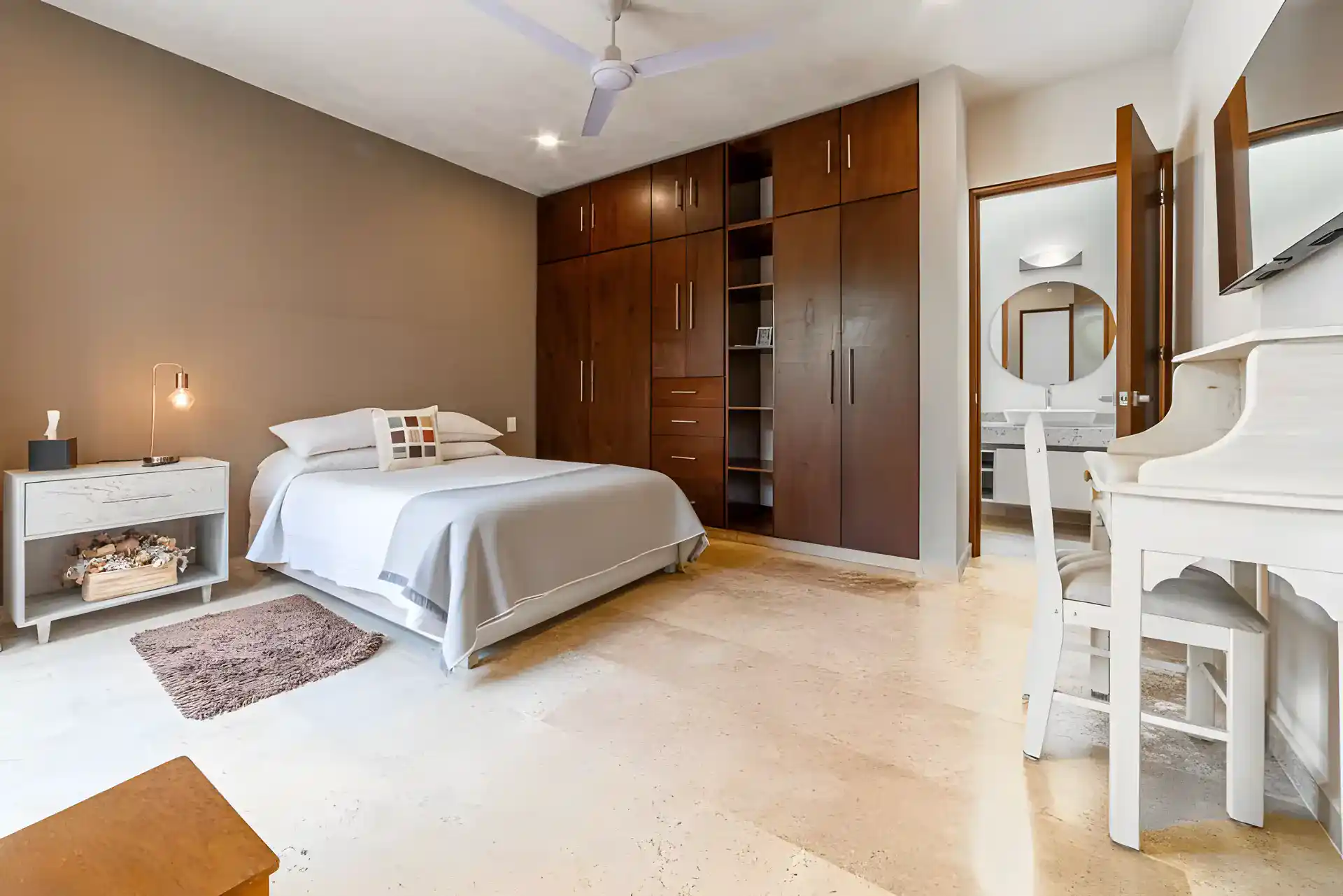 Casa Albero, bedroom with a bed, a wall of dark wood wardrobes, a vanity desk and an en suite bathroom, San Miguel de Allende