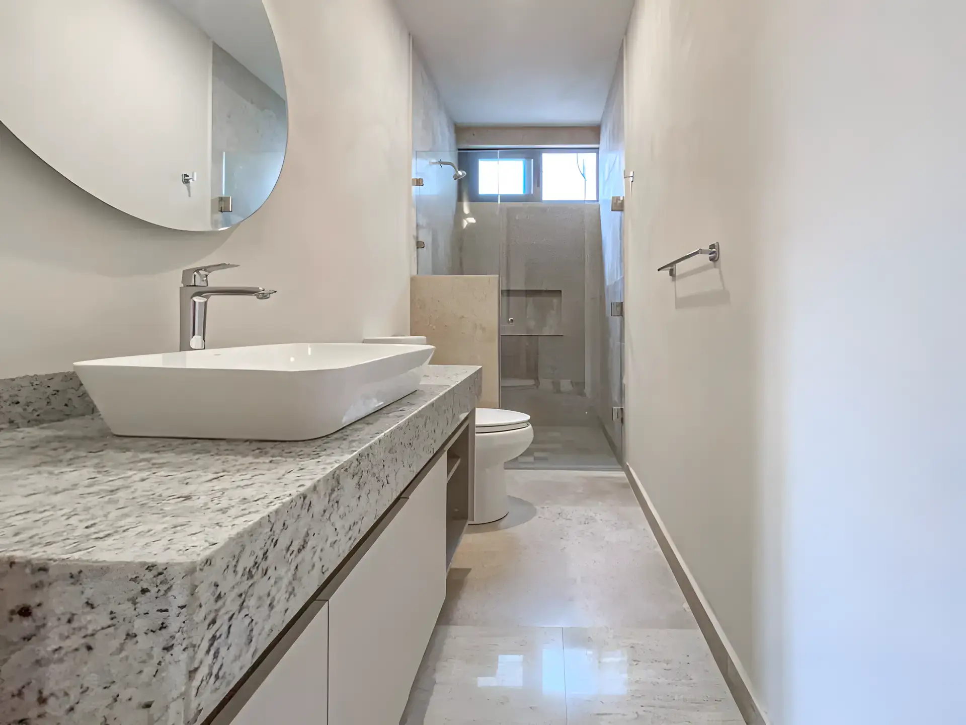Casa Albero, bathroom with a granite counter, a vessel sink, a round mirror and a glass-door shower, San Miguel de Allende