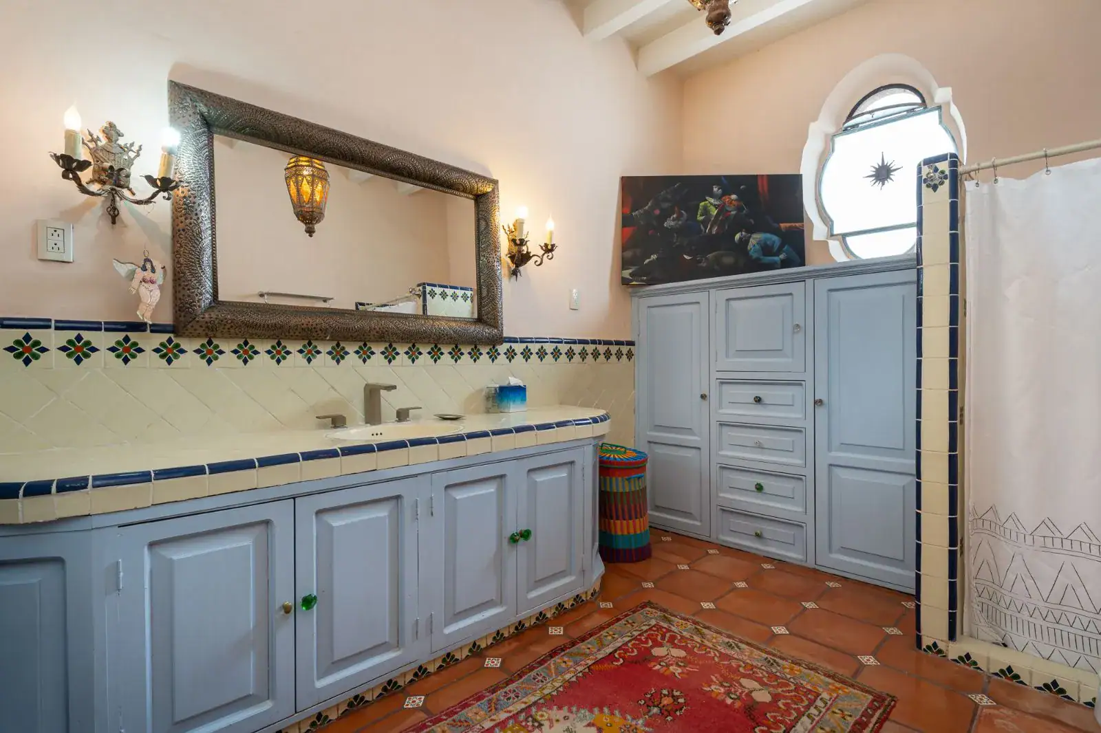 Casa Aldama, bathroom with a long blue cabinet vanity, tile backsplash and a carved mirror, San Miguel de Allende