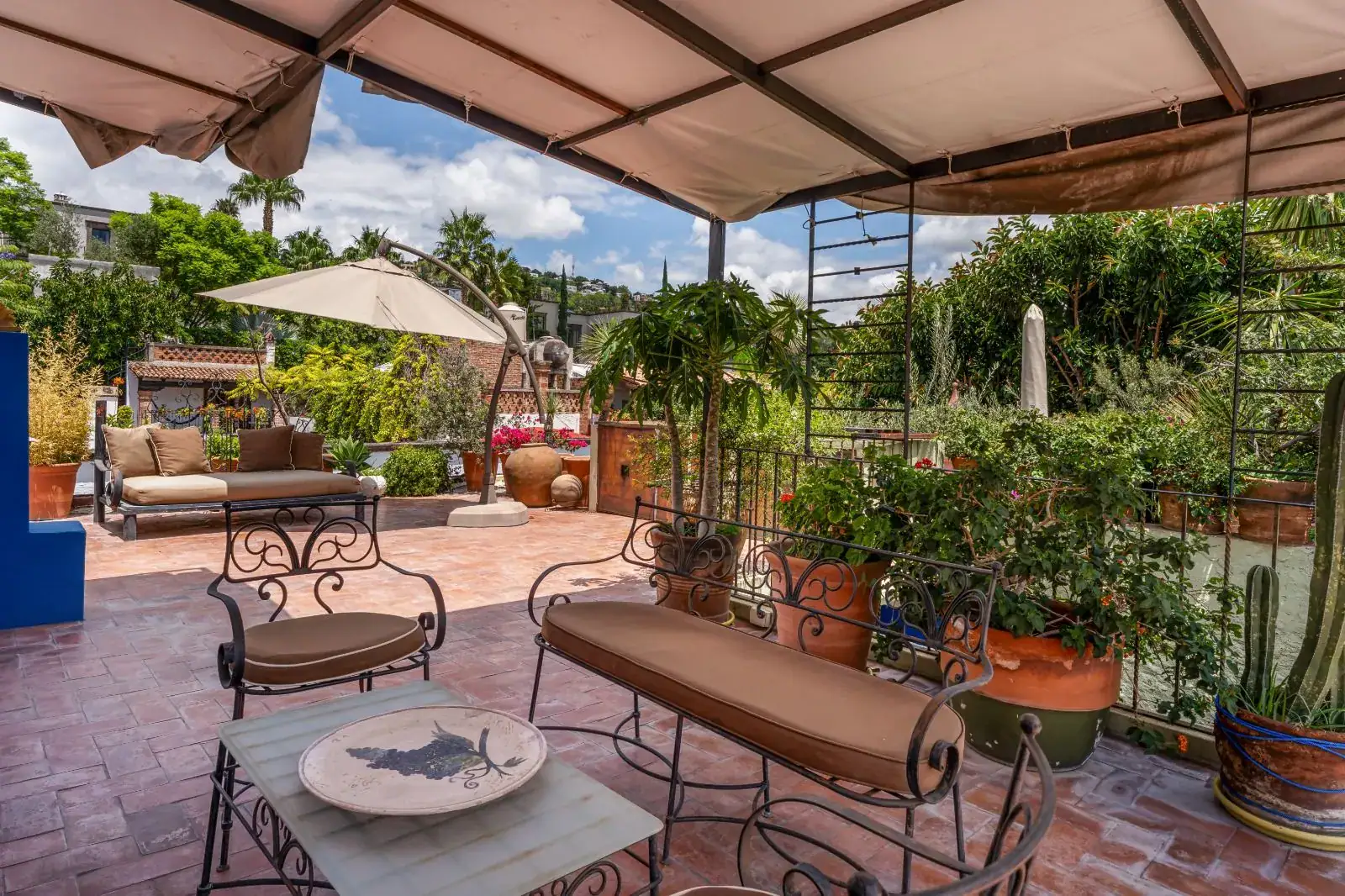 Casa Aldama, rooftop terrace with a canopy, wrought-iron seating and potted plants, San Miguel de Allende