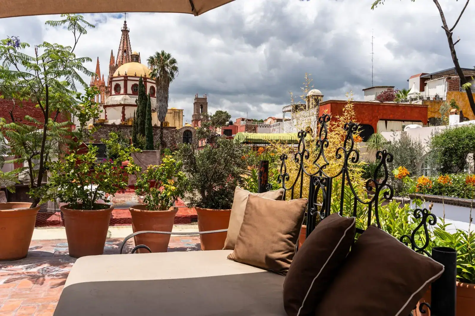 Casa Aldama, rooftop daybed with brown cushions and a view of the Parroquia and rooftops, San Miguel de Allende