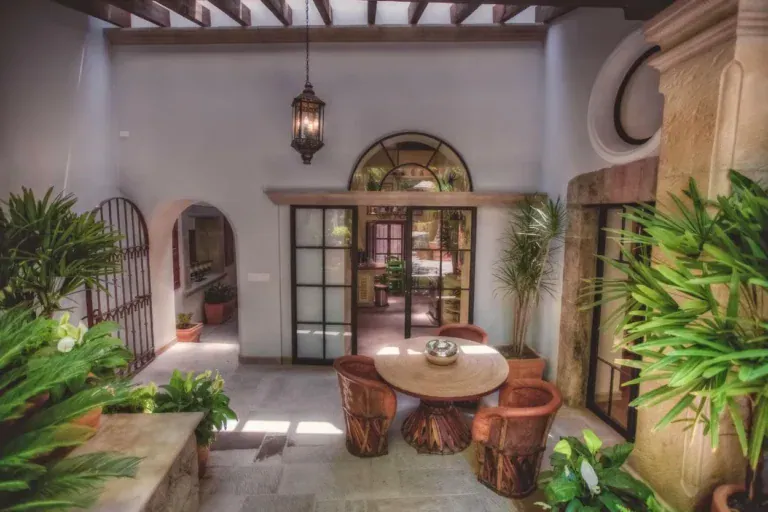 Casa Aldama, patio with a round table opening to a glass-walled room, San Miguel de Allende
