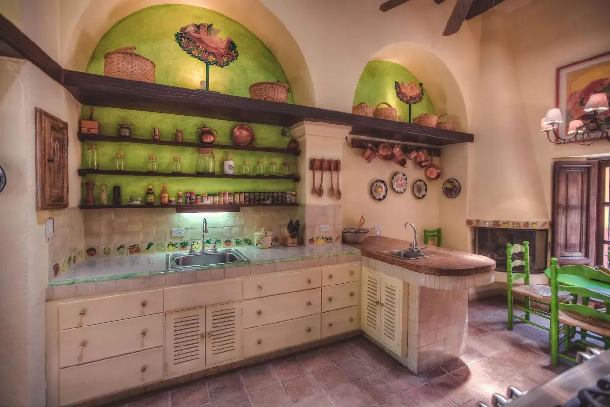 Casa Aldama, kitchen with green wall niches, copper pots and a breakfast table, San Miguel de Allende
