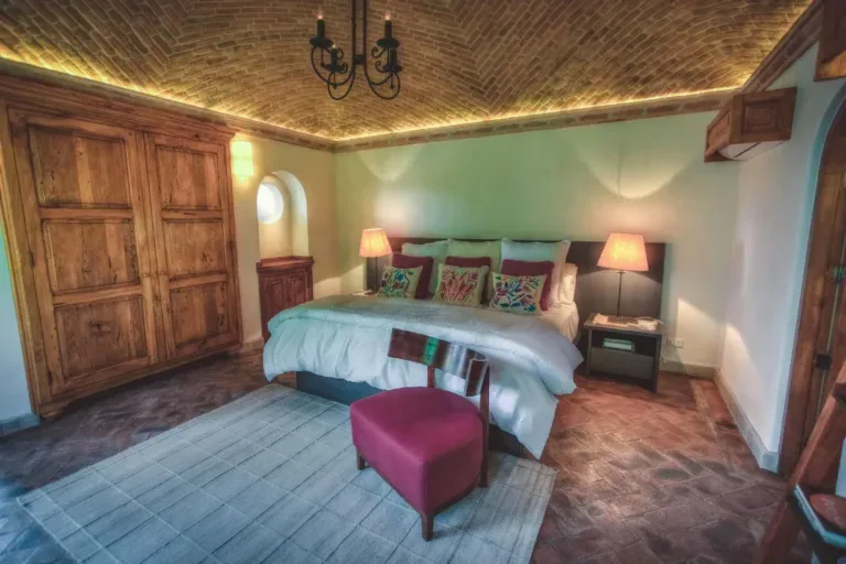 Casa Aldama, bedroom with a brick vaulted ceiling and a magenta bench, San Miguel de Allende