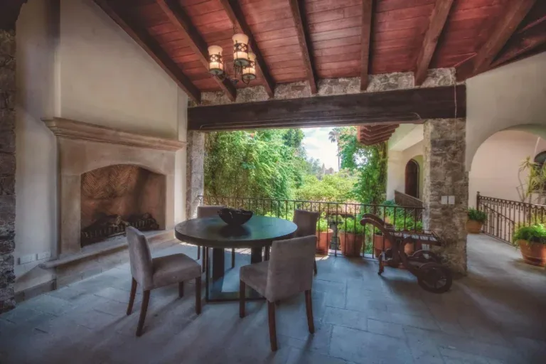 Casa Aldama, covered terrace with a stone fireplace and a dining table, San Miguel de Allende