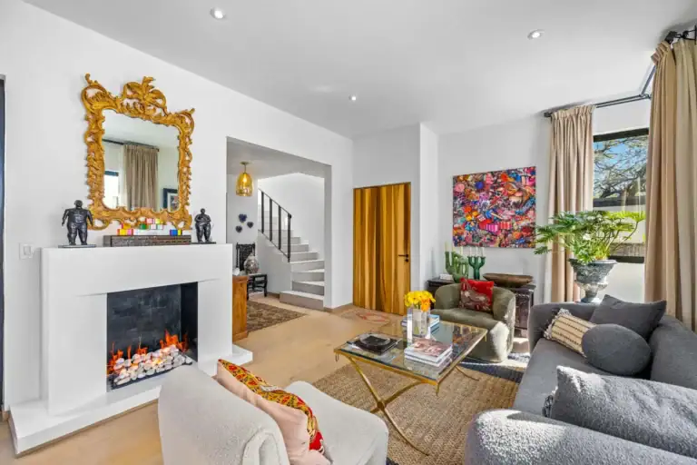 Casa Amoray, sitting area with a gold mirror and a white fireplace, San Miguel de Allende