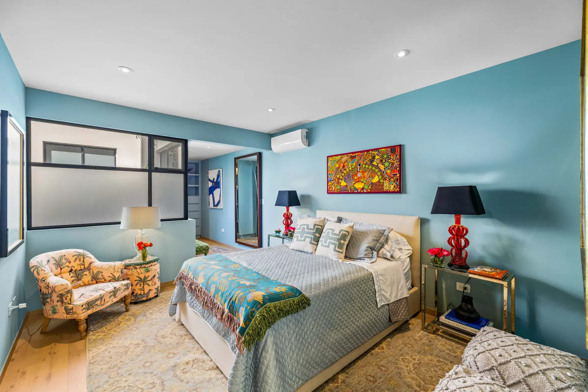 Casa Amoray, bedroom with blue walls, built-in shelves and a floral chair, San Miguel de Allende